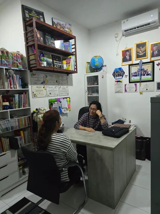 Ruang konseling dengan rak buku dan meja kerja psikolog