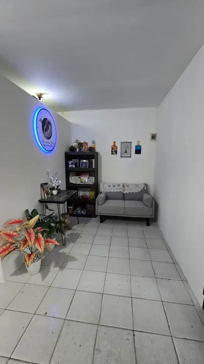 Ruang tunggu kantor dengan logo Hear For You bercahaya di dinding