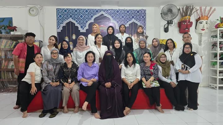 Para ibu, anak, dan tim Hear For You berfoto bersama di dalam ruangan